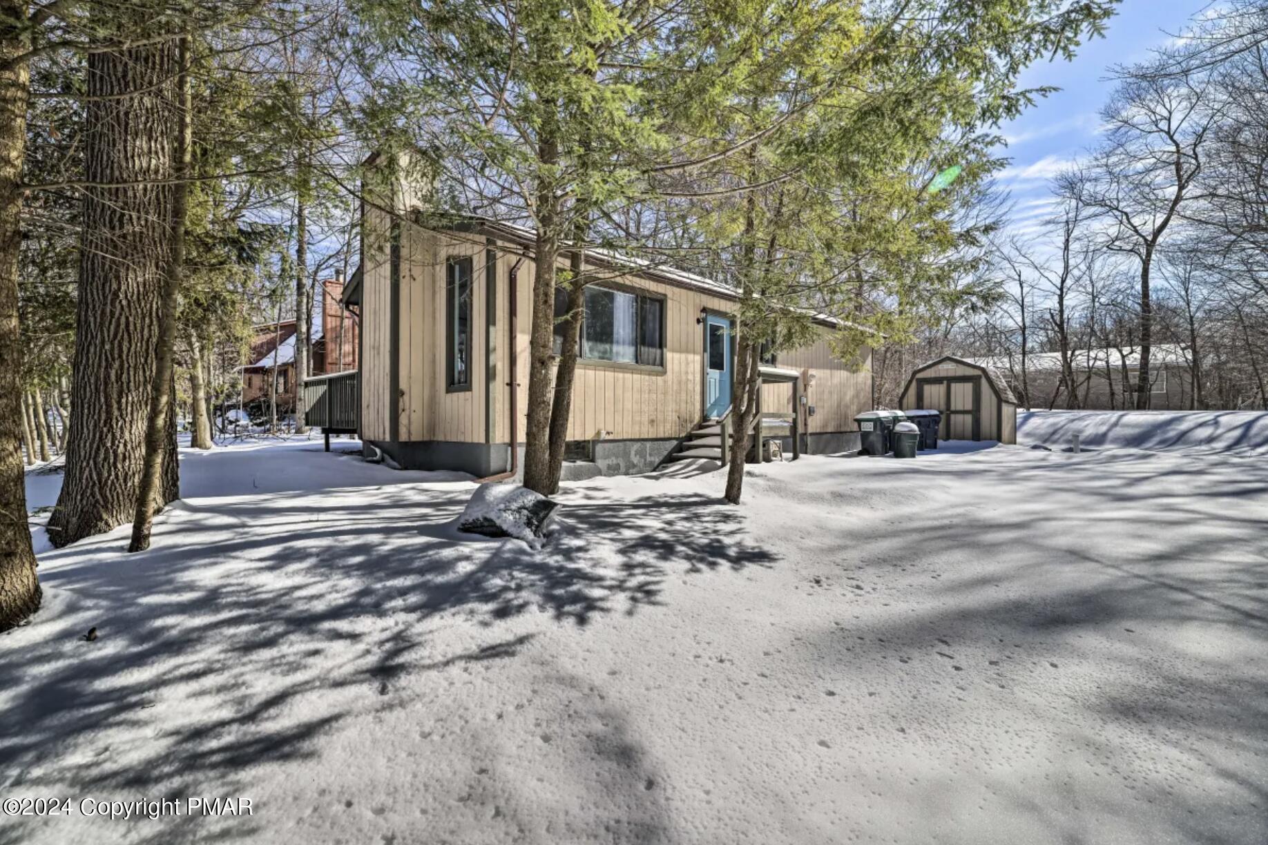 a front view of a house with a yard covered in snow