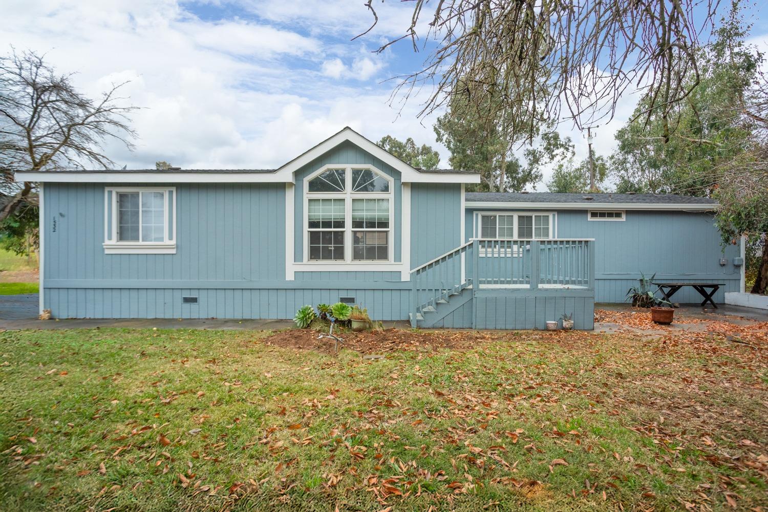 a front view of house with yard and trees in the background