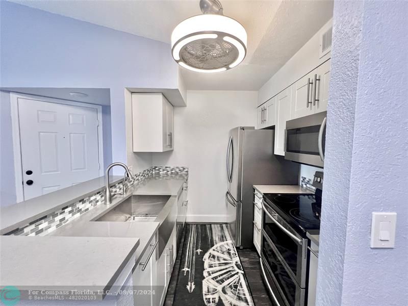 a kitchen with a sink stove and refrigerator