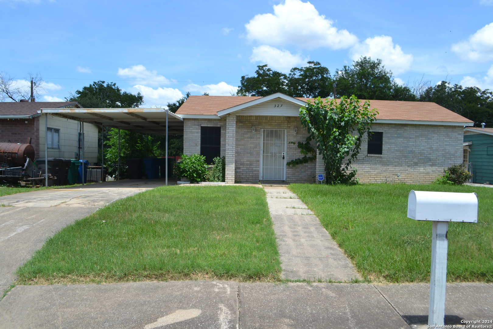 a front view of a house with a yard and potted plants