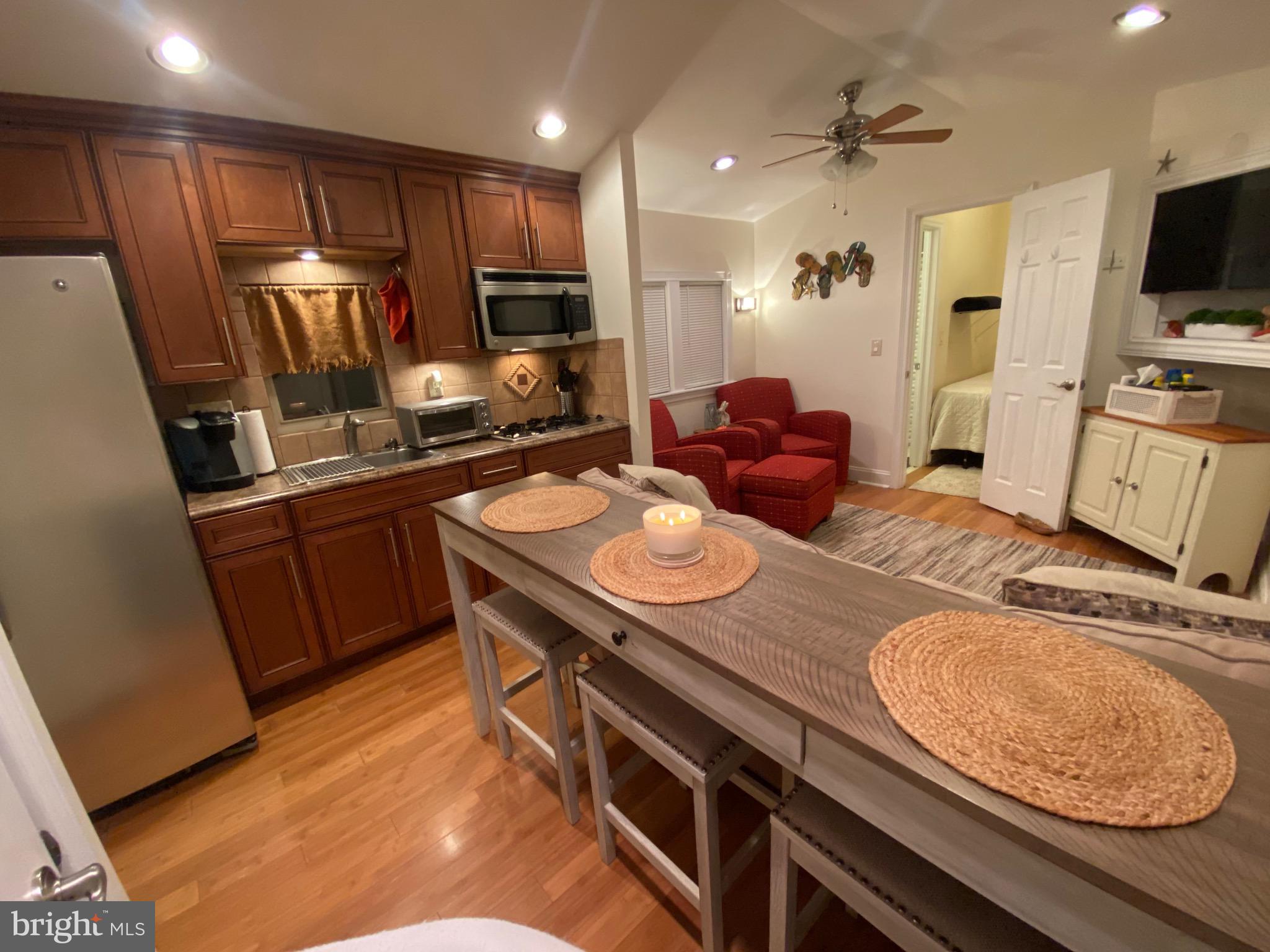 a kitchen with stainless steel appliances granite countertop a sink dishwasher stove and refrigerator with wooden floor