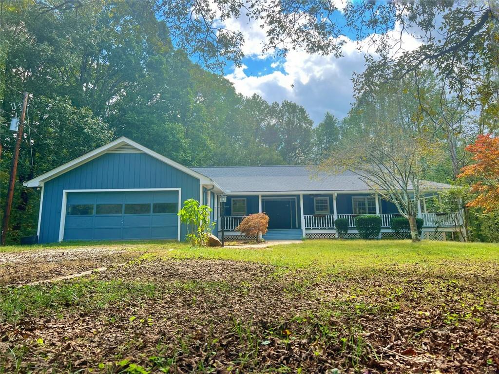 a front view of house with yard and trees in the background