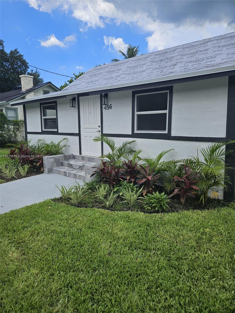 a front view of a house with a garden