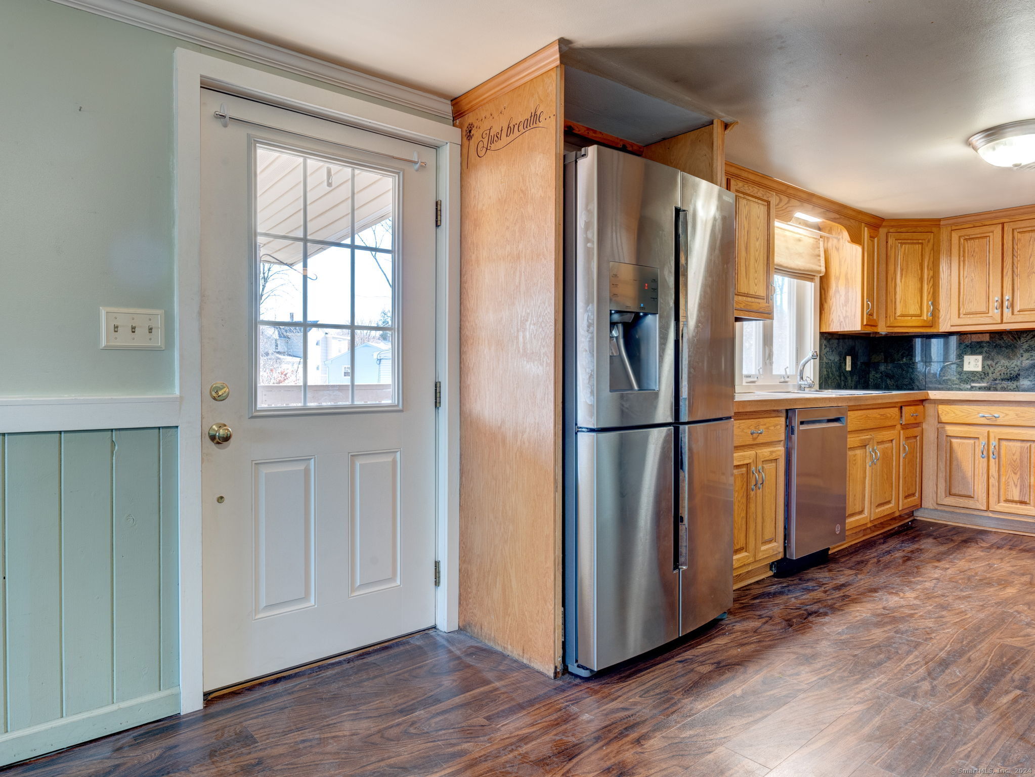 a kitchen with cabinets a refrigerator and wooden floor