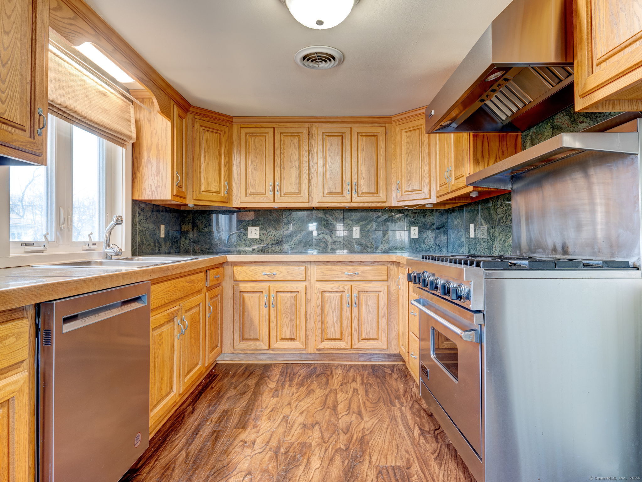 a kitchen with granite countertop a sink a stove and cabinets