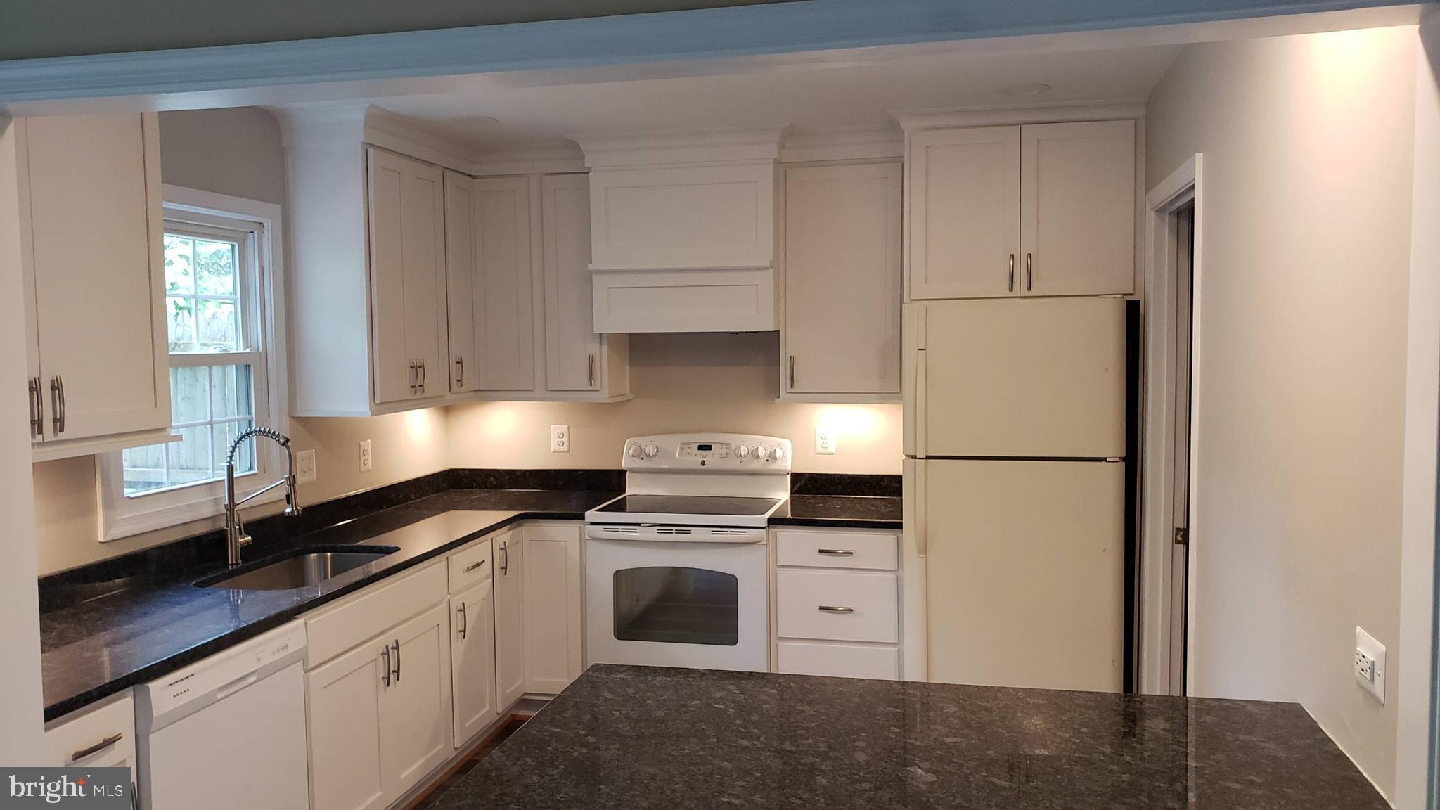 a kitchen with white cabinets and white appliances