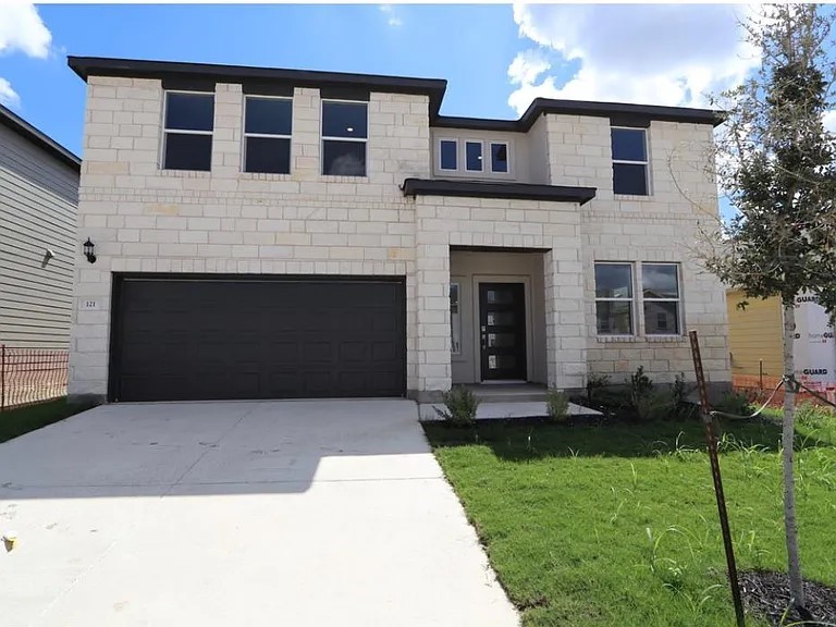 a front view of a house with a yard and garage