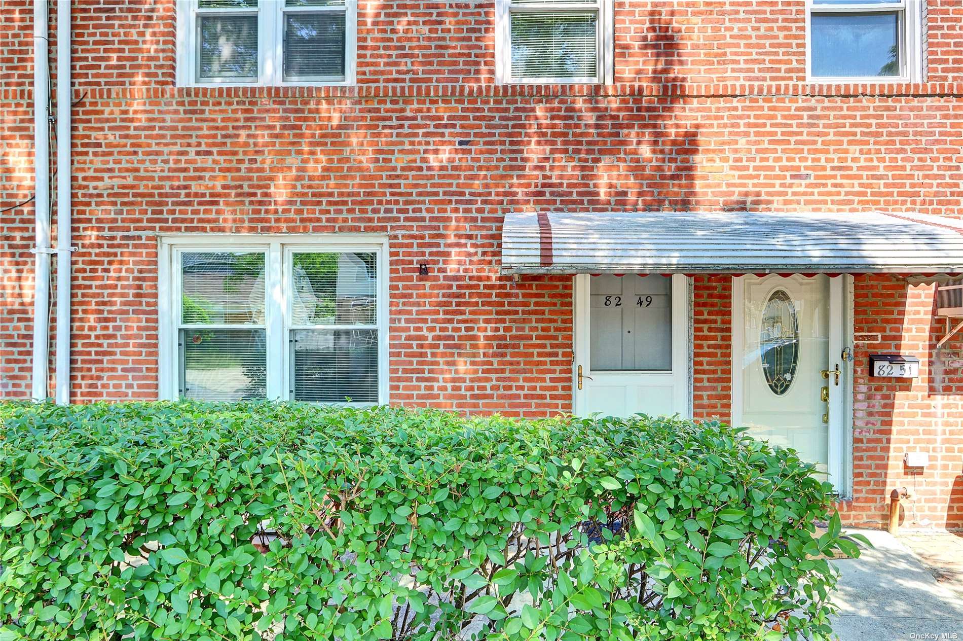 a view of a brick house with large windows and a flower plant