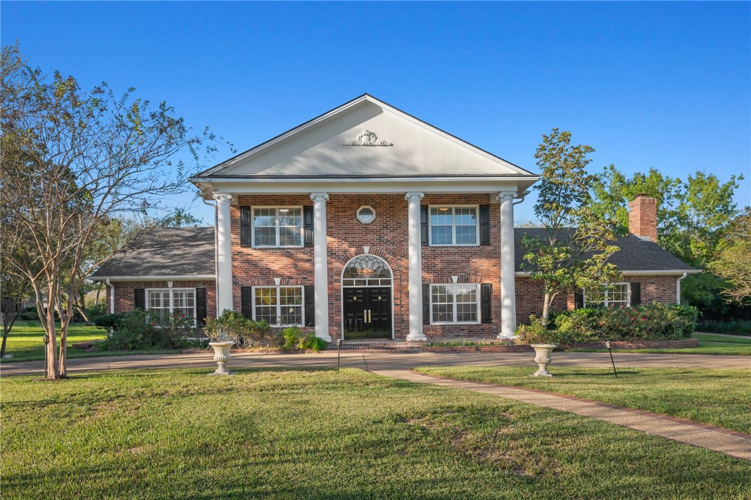 Greek revival inspired property with a front yard