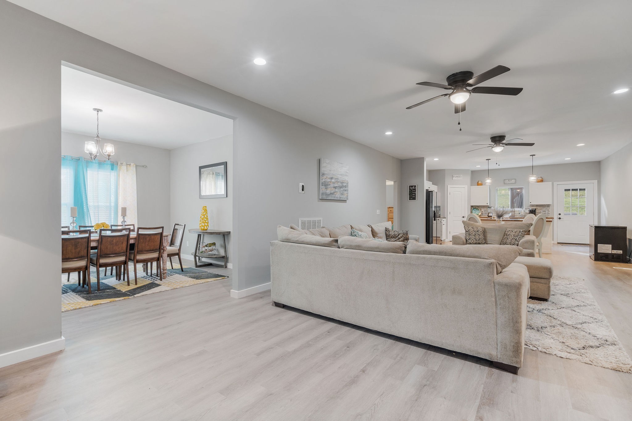 a living room with furniture a dining table and chairs with kitchen view