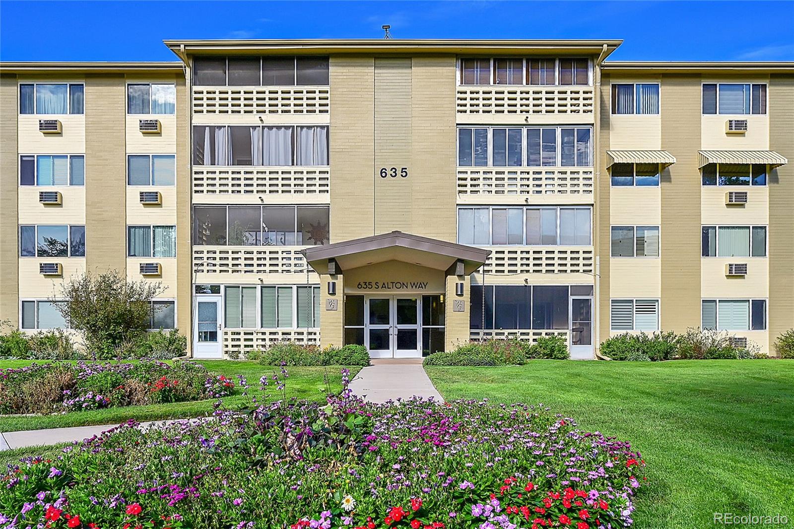 a front view of a building with a garden and pathway