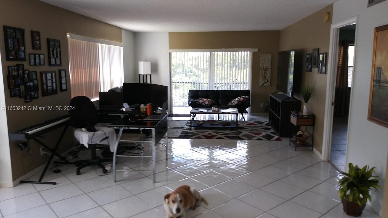 a living room with furniture a window and a flat screen tv