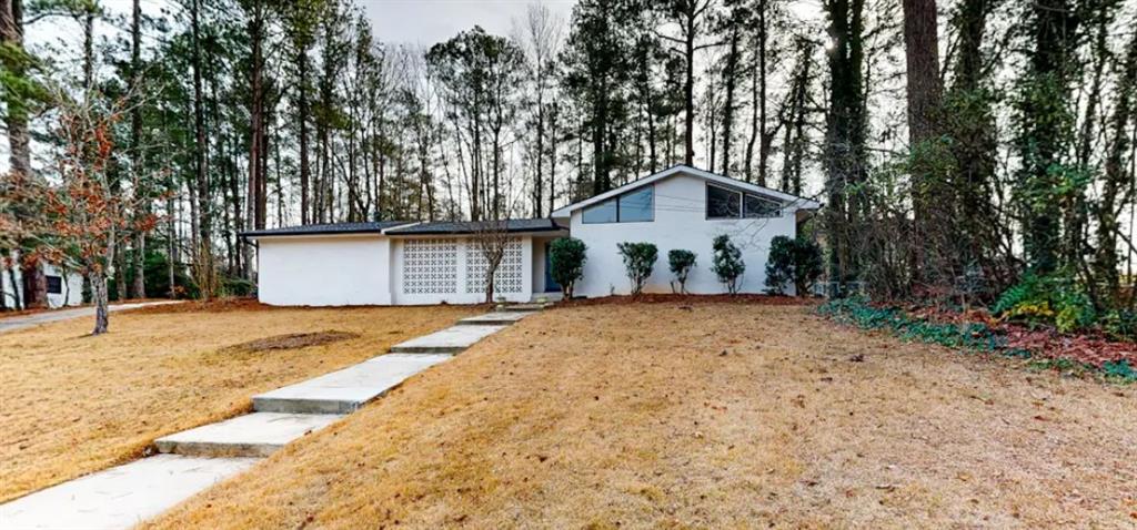 a front view of a house with a yard and trees