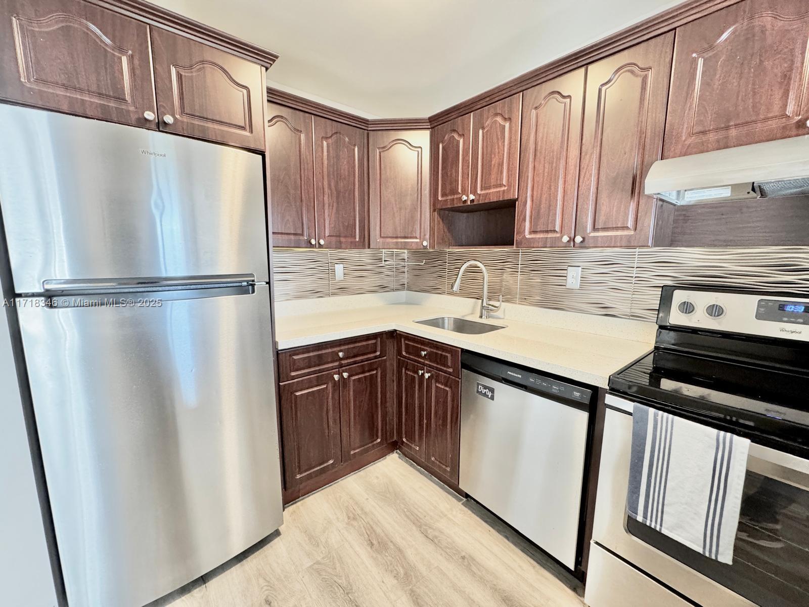 a kitchen with a refrigerator a sink and cabinets