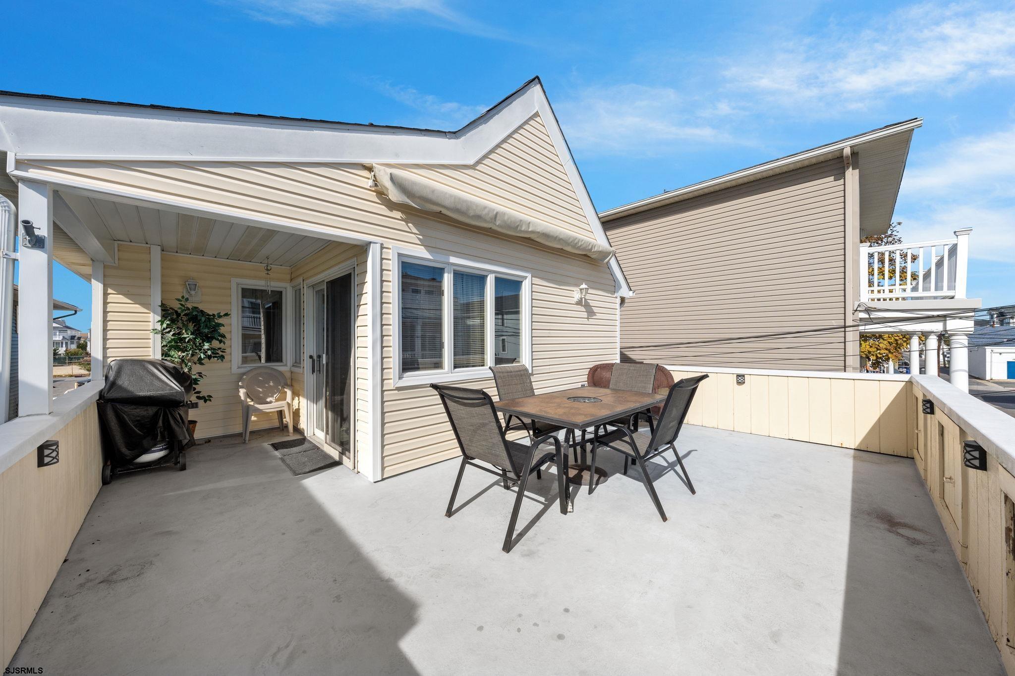 a view of a patio with dining table and chairs with wooden floor and fence