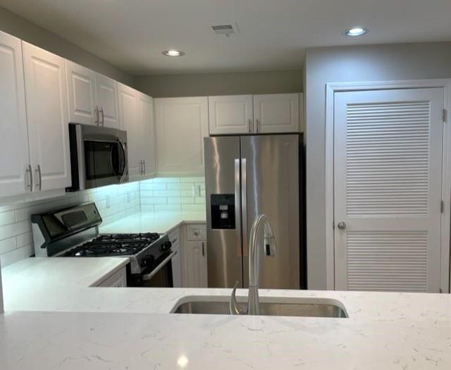 a kitchen with stainless steel appliances a refrigerator and a stove