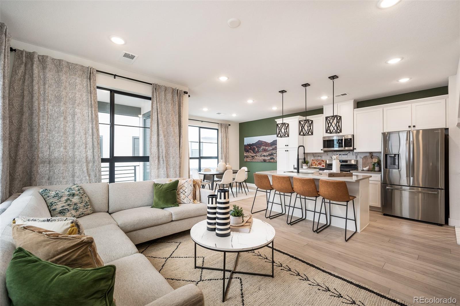 a living room with furniture kitchen and a refrigerator