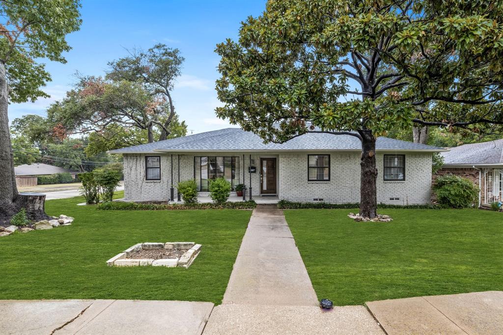 a front view of a house with a yard and trees