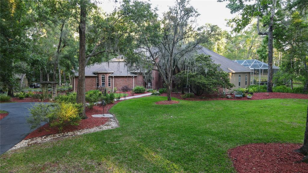 a front view of a house with a garden and trees