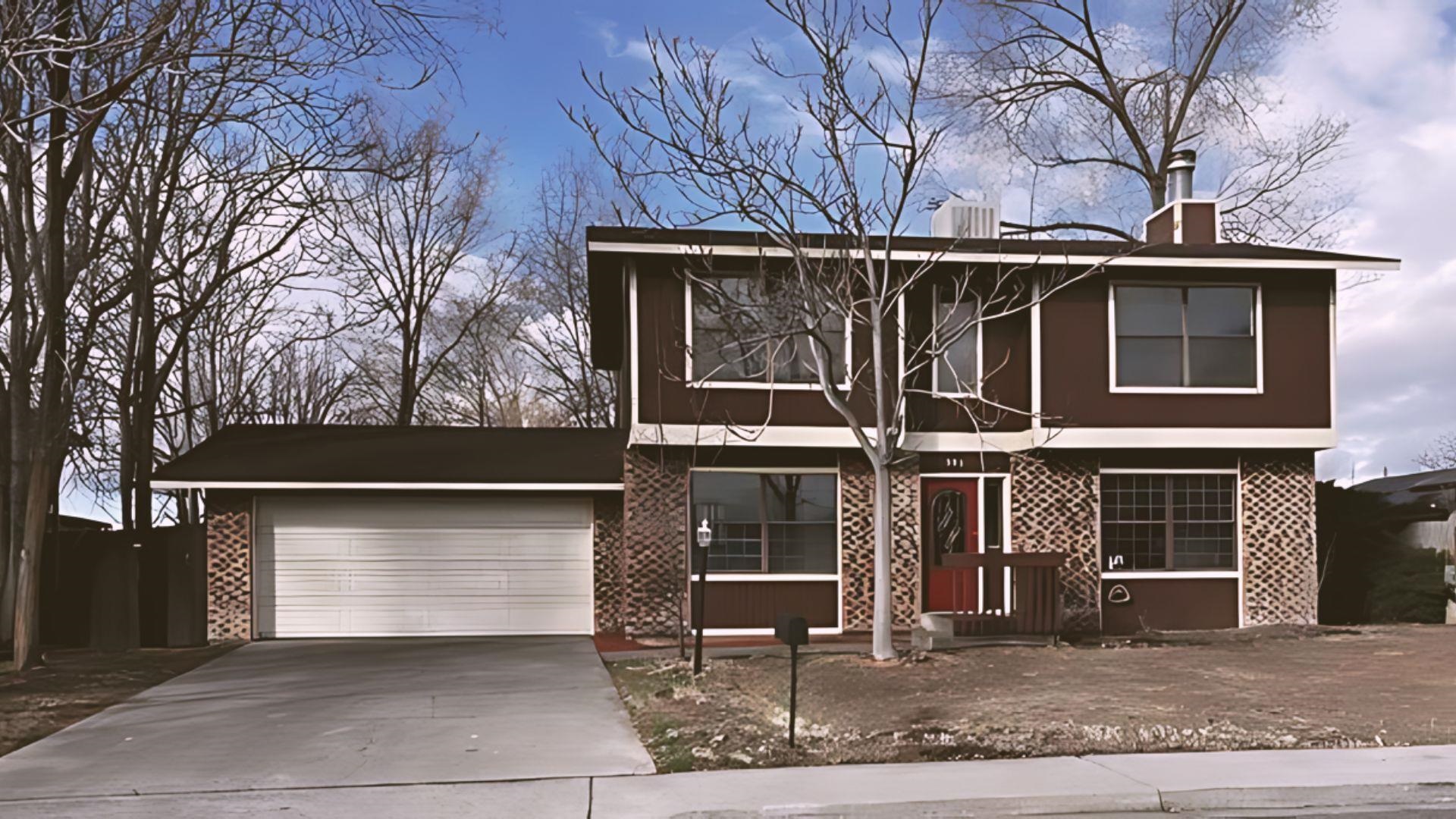 a view of a house with large windows and a tree