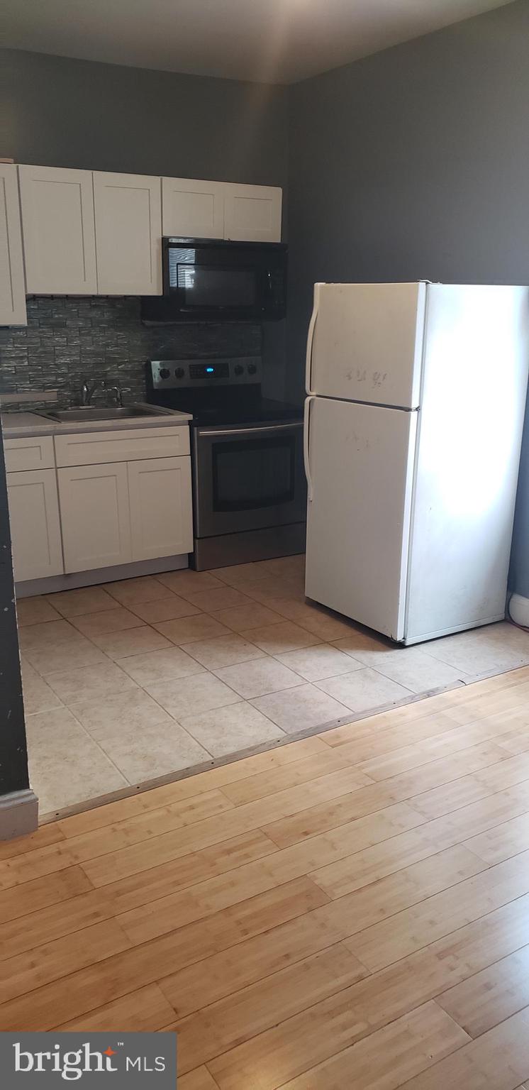 a kitchen with granite countertop a refrigerator and a stove