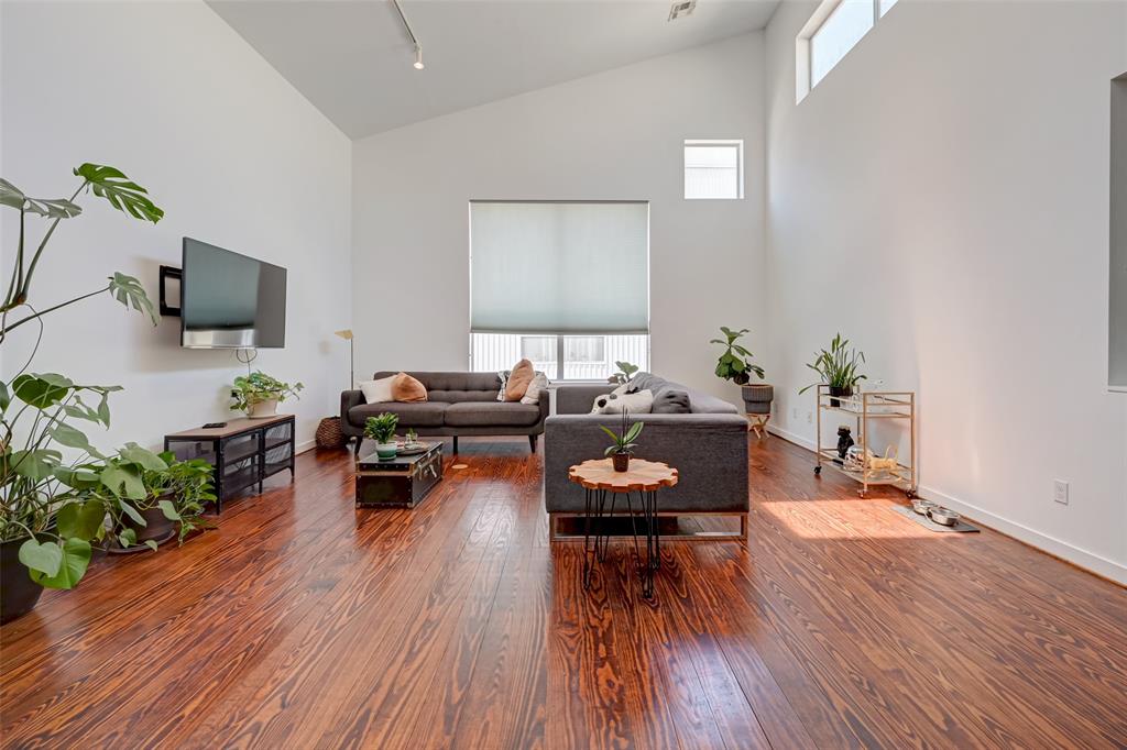 a living room with furniture a wooden floor and a flat screen tv