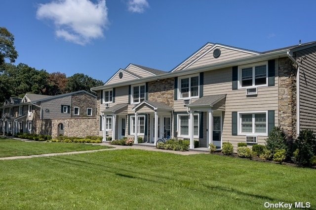 a front view of a house with a garden and lake view