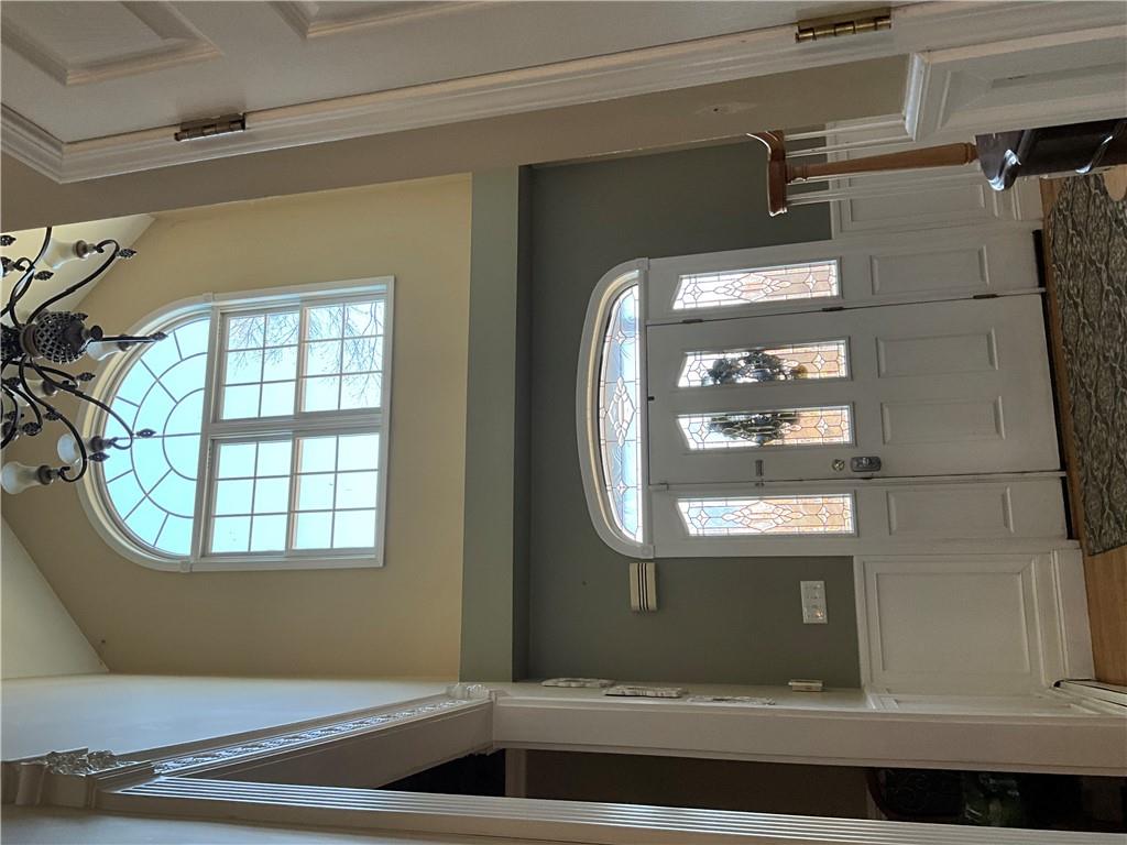 Foyer entrance featuring a notable chandelier, a baseboard heating unit, hardwood / wood-style flooring, and lofted ceiling