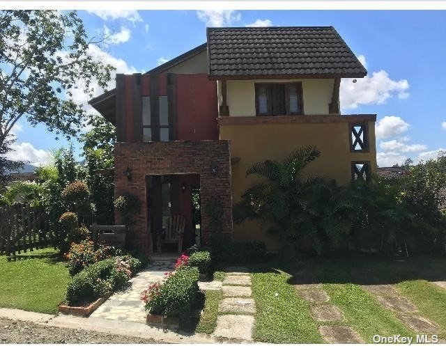 a front view of a house with a garden