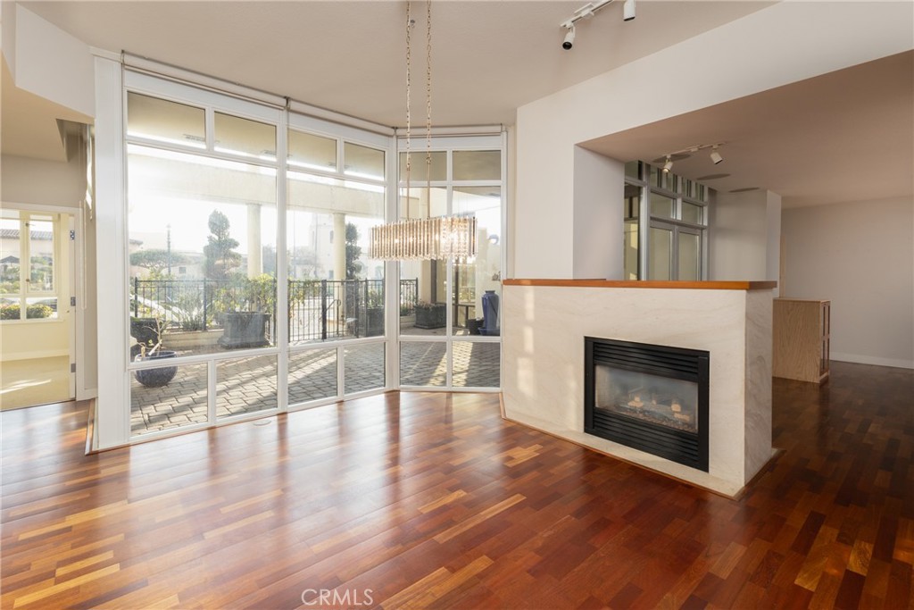 a view of an empty room with wooden floor and a fireplace