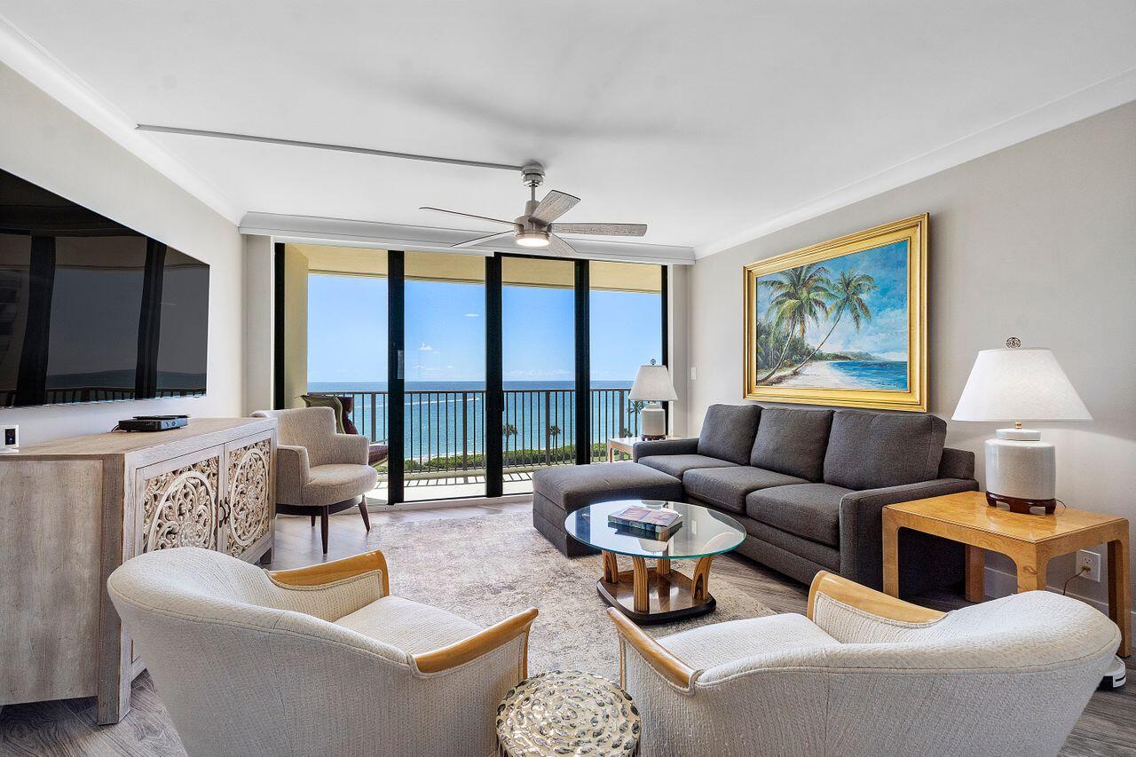 a living room with furniture a flat screen tv and a large window