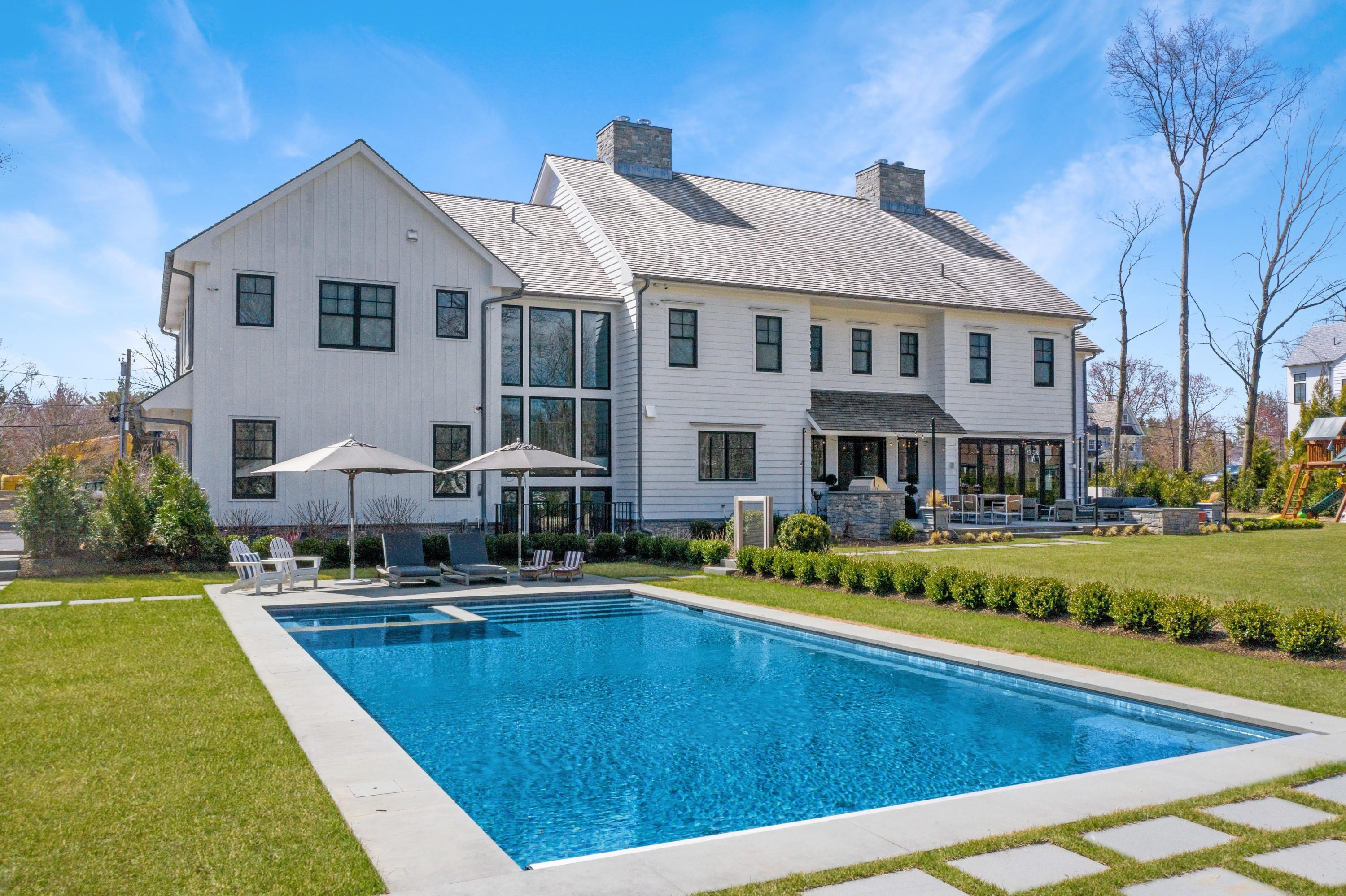 a front view of a house with swimming pool having outdoor seating