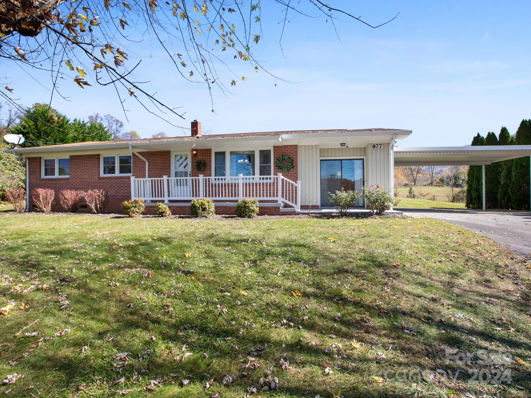 a front view of a house with a yard and trees