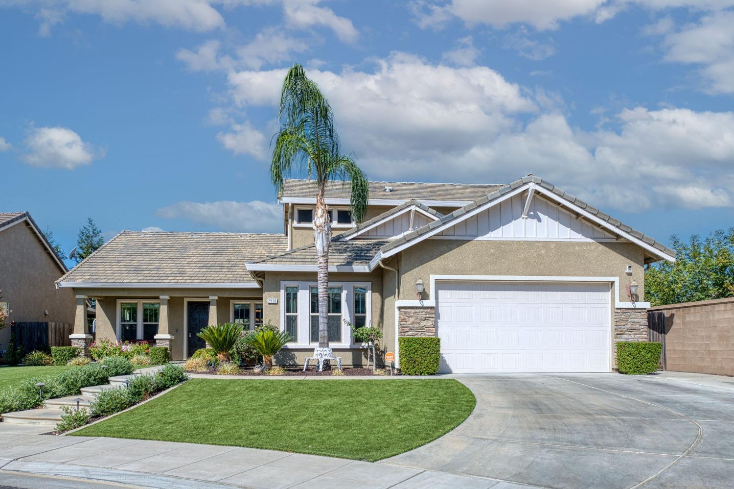 a front view of a house with a yard and potted plants