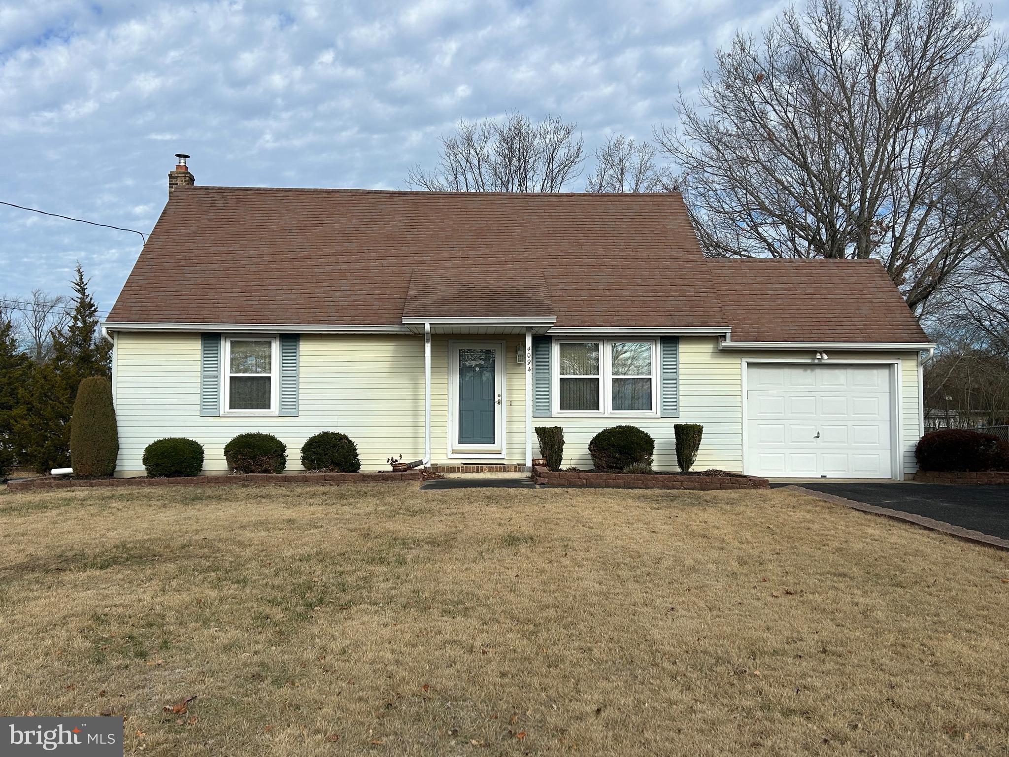 a view of a house with a yard and large tree