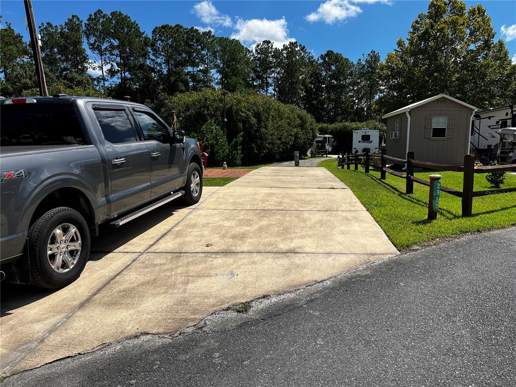 a view of a car parked in front of a house with wooden fence