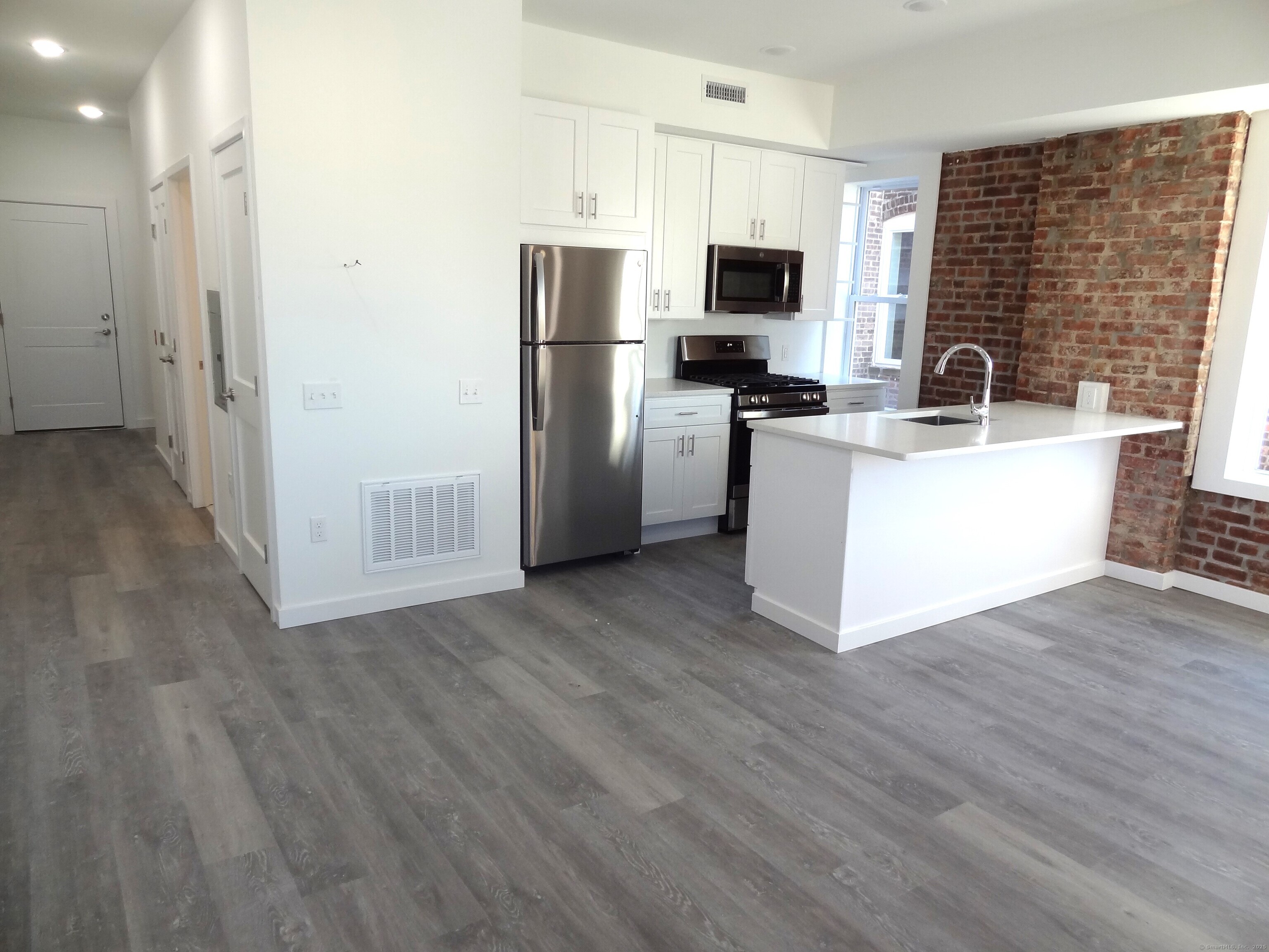 a kitchen with a refrigerator microwave and sink