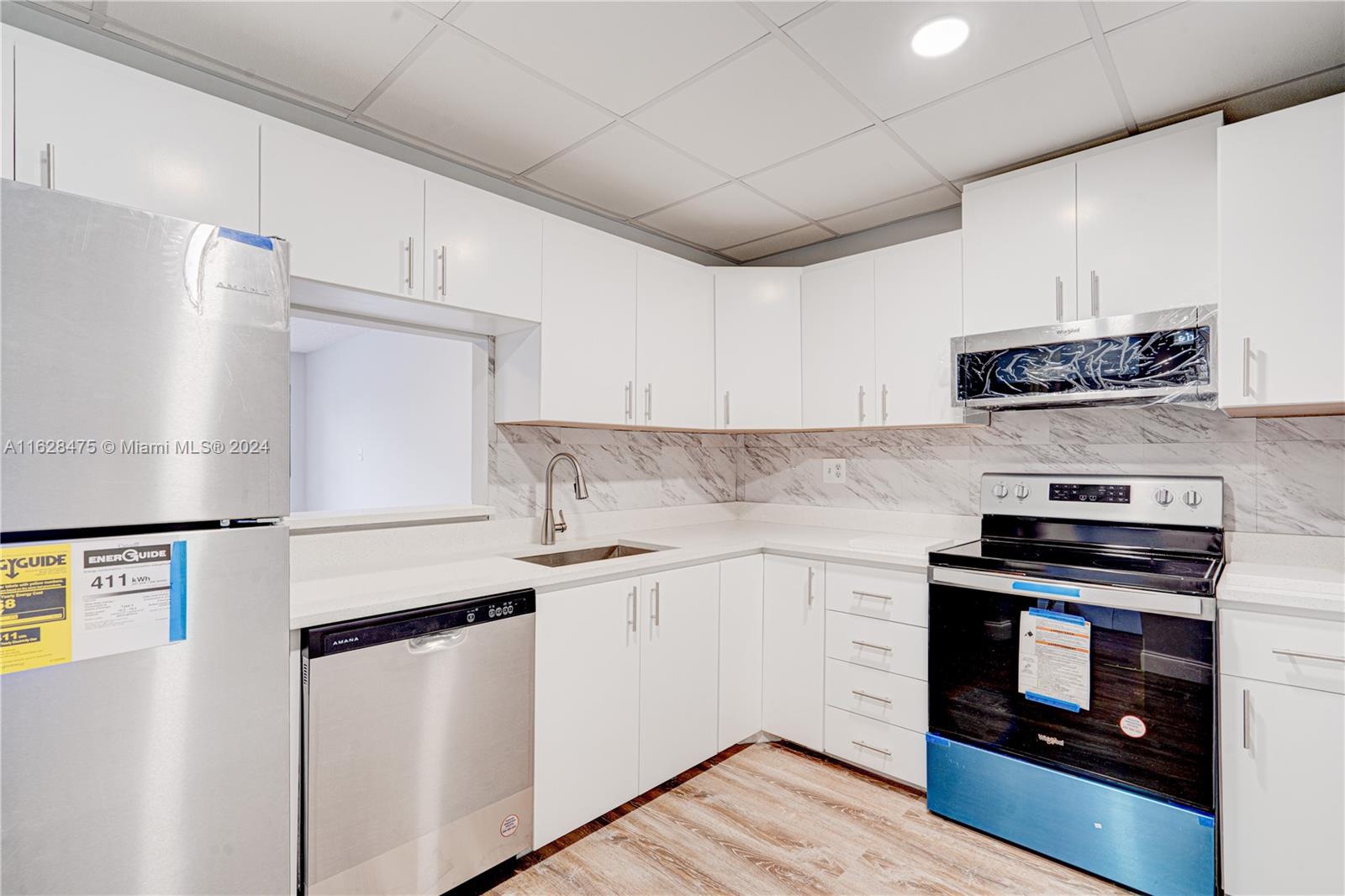 a kitchen with stainless steel appliances a stove a sink and a refrigerator