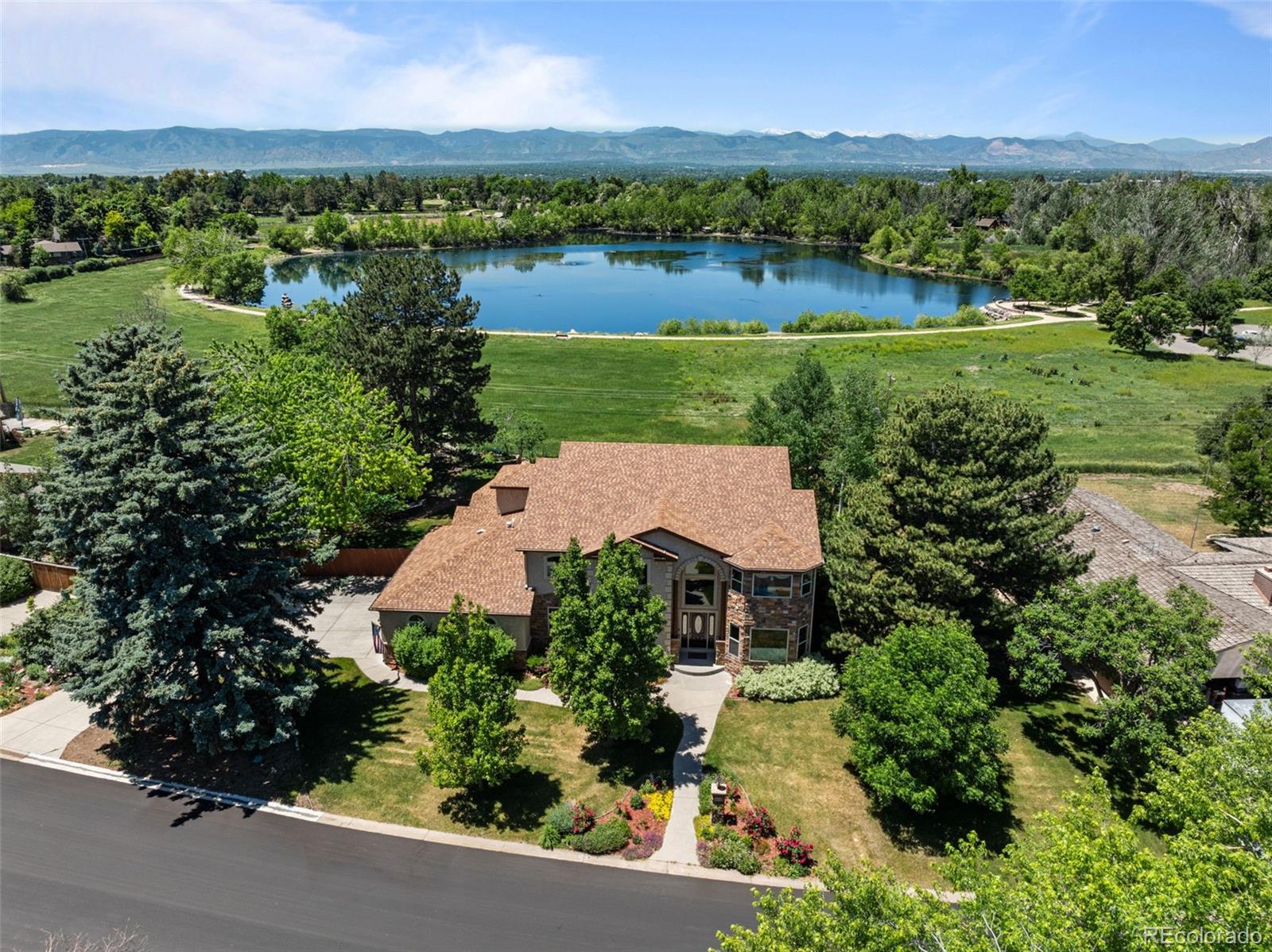 an aerial view of a house with a yard and lake view