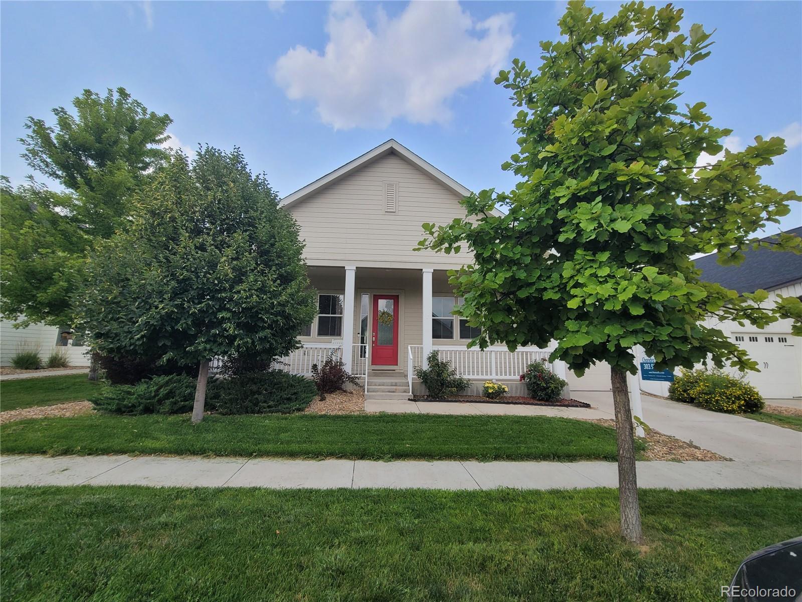 a front view of a house with a yard and trees