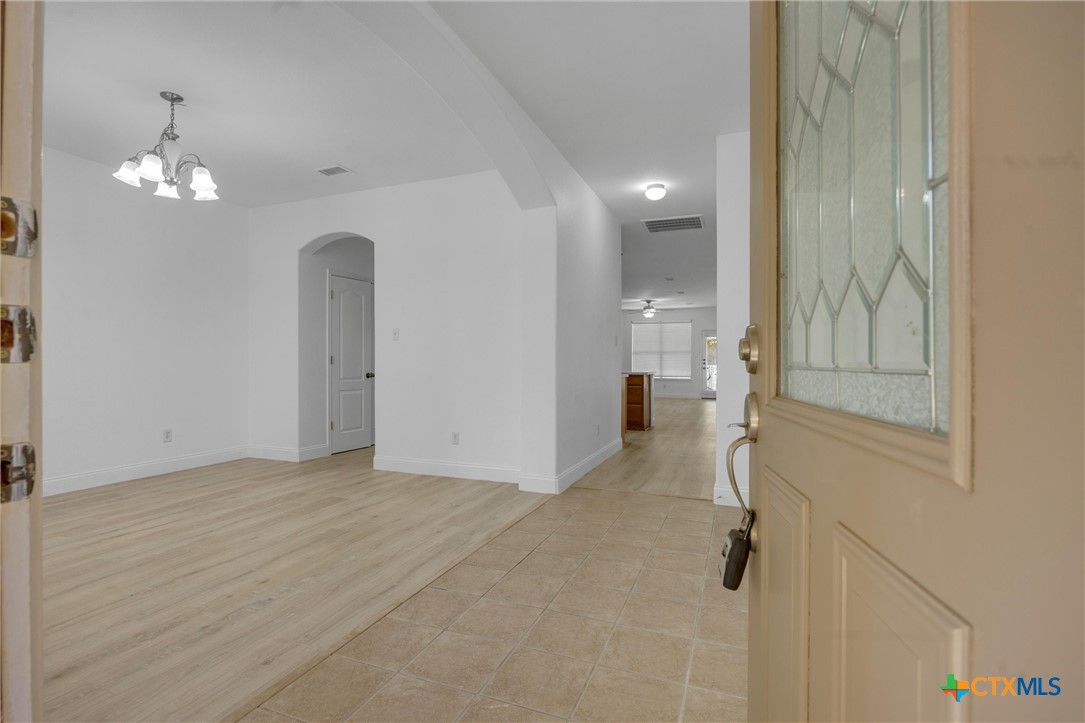 a view of a room with a chandelier fan and windows