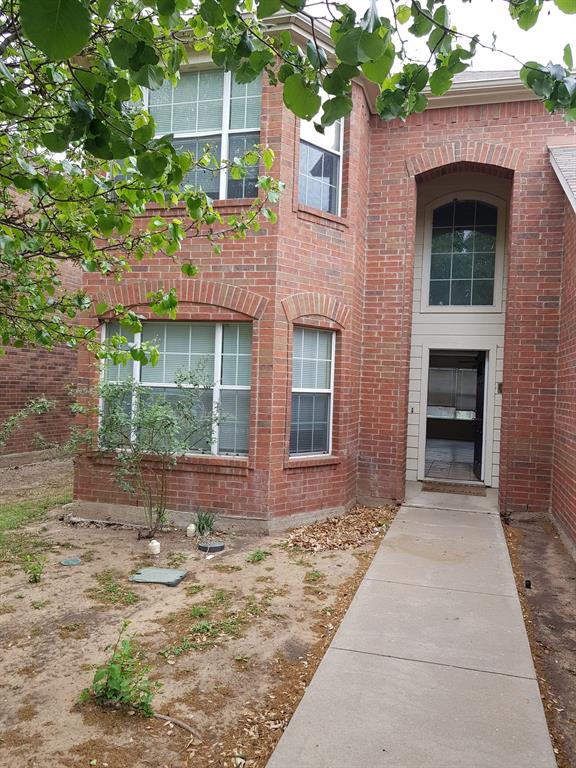 a front view of a house with a yard and potted plants