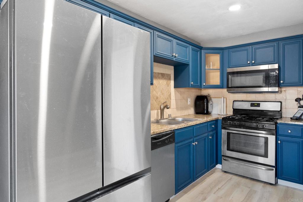 a kitchen with stainless steel appliances a stove sink microwave and refrigerator