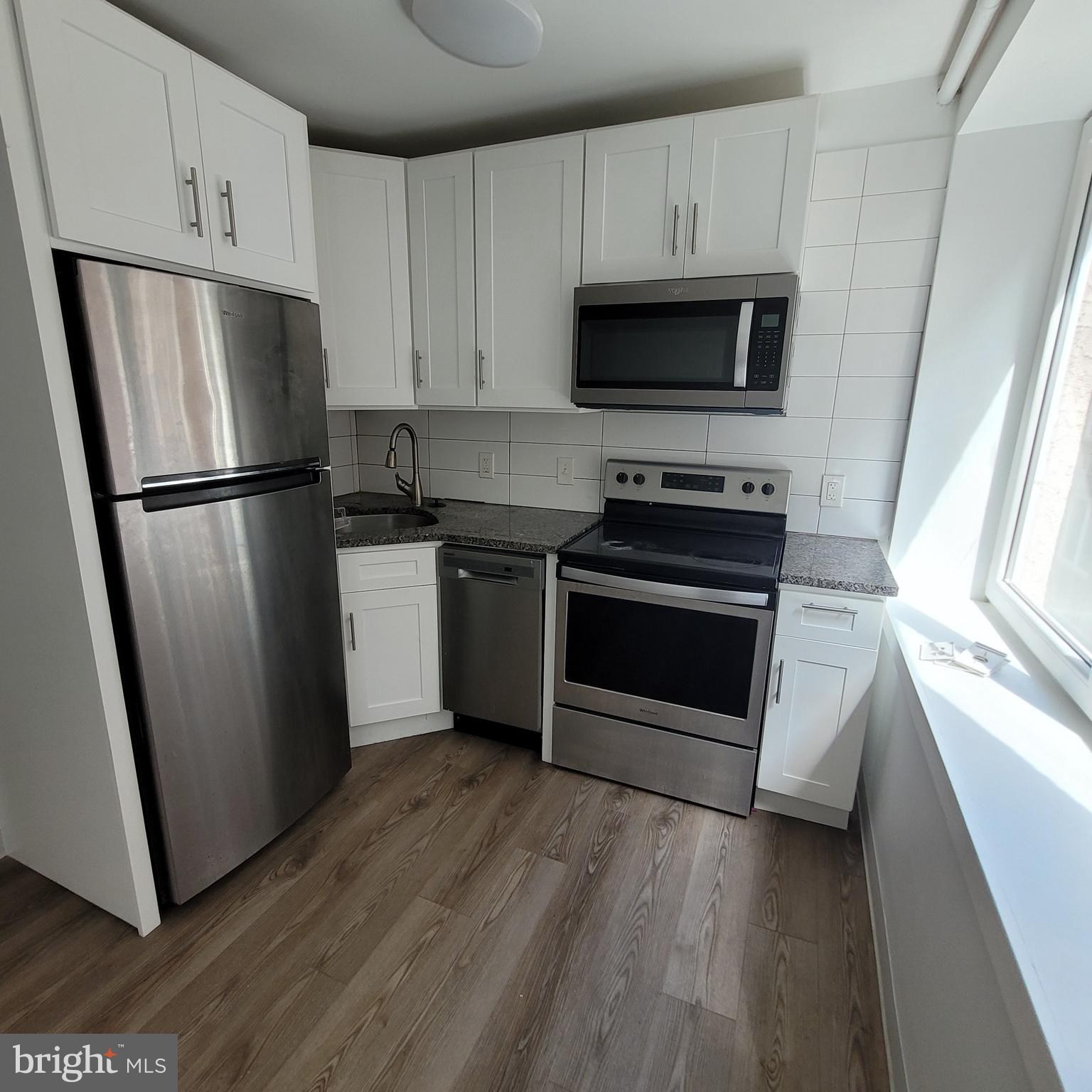 Fully renovated kitchen with white cabinetry.