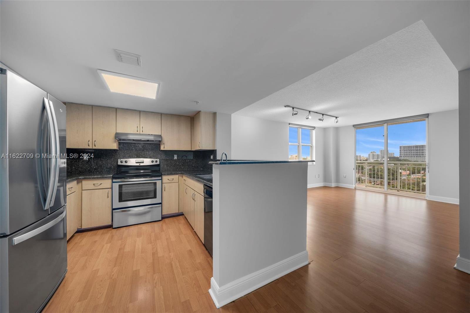 a kitchen with granite countertop a refrigerator and a stove top oven