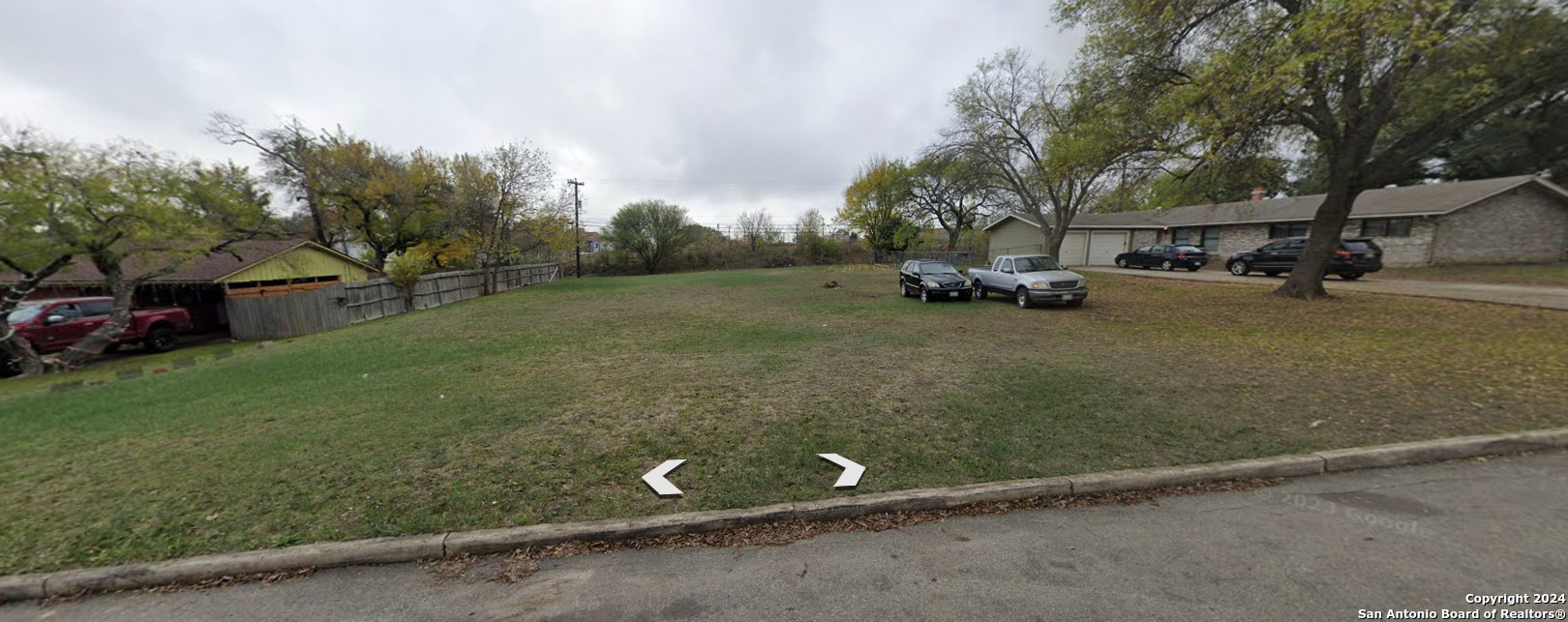 a view of a street with parked cars