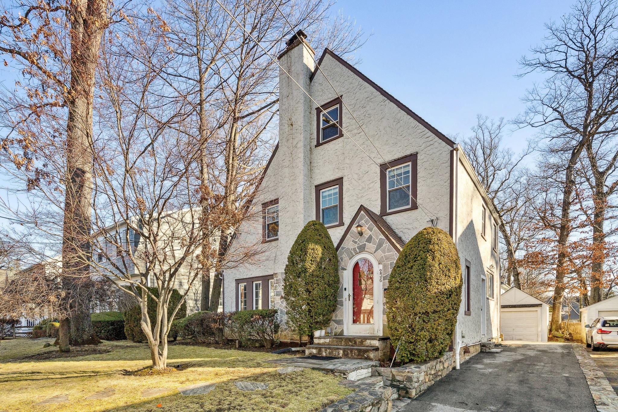 English style home featuring an outbuilding, a front yard, and a garage