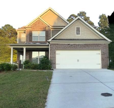 a front view of a house with a yard and garage