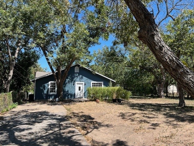 a front view of house with yard and trees around