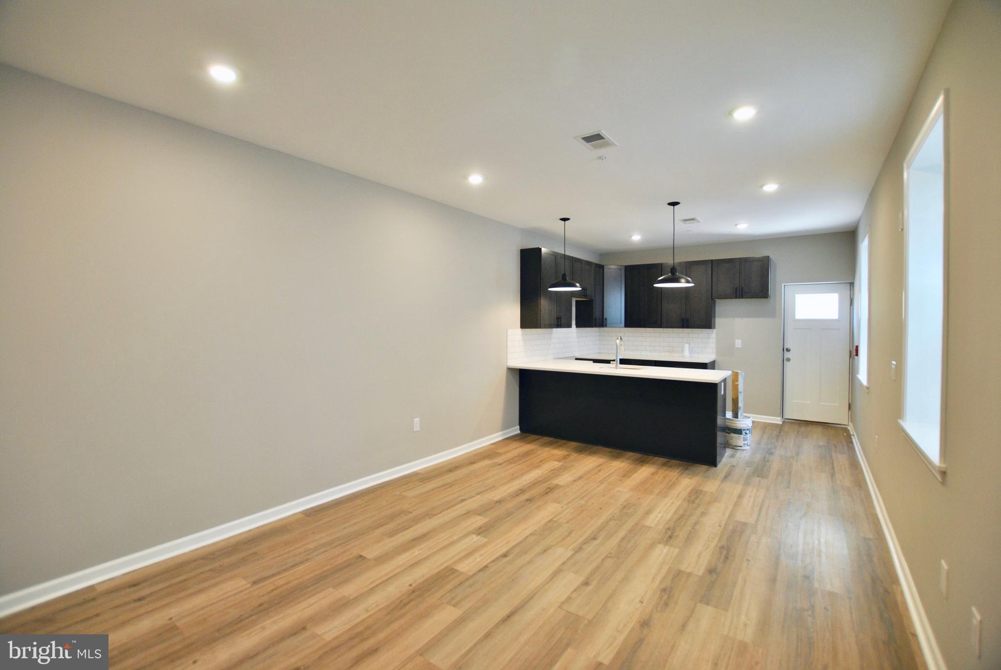 a large kitchen with a sink stainless steel appliances and cabinets